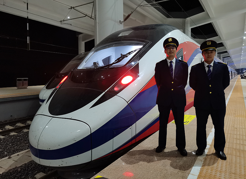 劉銀能（右一）與中國師父鄔俊鴻在動(dòng)車組前合影。受訪者供圖